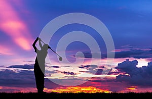 Silhouette golfer playing golf at beautiful sunset
