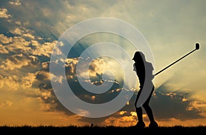 Silhouette golfer playing golf at beautiful sunset