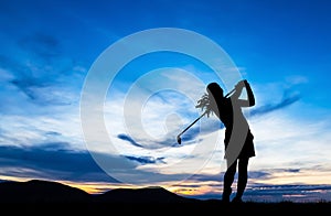 Silhouette golfer playing golf at beautiful sunset