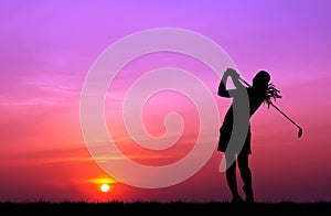 Silhouette golfer playing golf at beautiful sunset