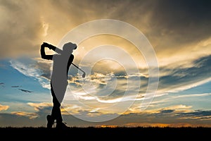 Silhouette golfer playing golf at beautiful sunset