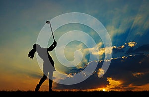 Silhouette golfer playing golf at beautiful sunset