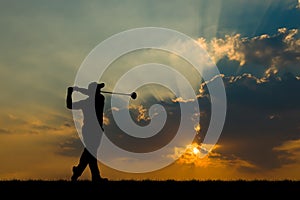 Silhouette golfer playing golf at beautiful sunset