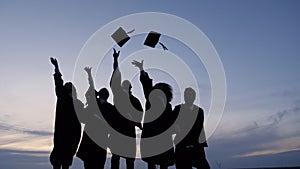 Silhouette of Graduating Students Throwing Caps In The Air.