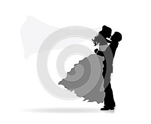 Silhouette of a groom holding his bride. The veil of the bride is flying.