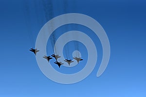 Silhouette of a group of Russian fighter aircraft against a blue sky. Six Russian fighter aircraft