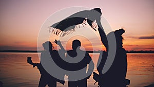 Silhouette of Group young dancing people have a party at beach on sunset