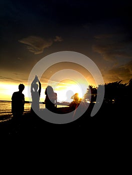 silhouette of a group of youths playing on the beach