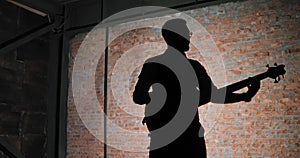 A silhouette of a guitar player, brick wall background