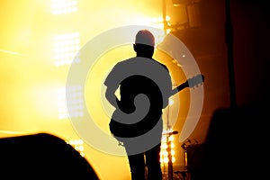 Silhouette of guitar player, guitarist perform on concert stage.