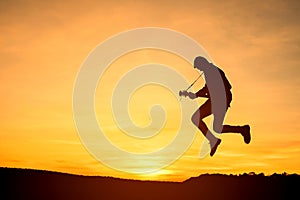 Silhouette of guitar player jump on stone