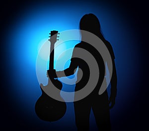 Silhouette guitarists of a rock band with guitar on blue background