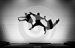 Silhouette of gymnasts on trampoline photo