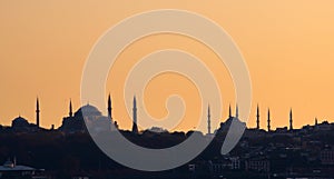 Silhouette of Hagia Sophia and the Blue Mosque of Sultanahmet, in Istambul, Turkey, against the ochre afternoon sky. photo