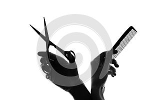 Silhouette hand with a comb and scissors