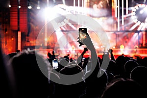 Silhouette of a hand with a mobile phone camera and enjoying the concert