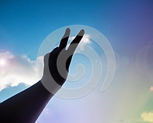 The silhouette hand showing two fingers up in the air,fighting symbol,Hand sign reach to the sky background