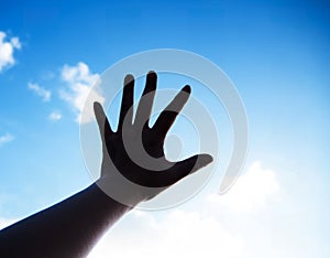 The silhouette hand sign reach to the sky background