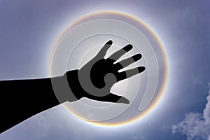 Silhouette hand on sun Halo background