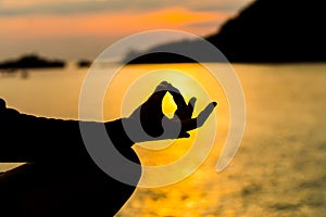 Silhouette, hand of Woman Meditating in Yoga pose or Lotus Posit