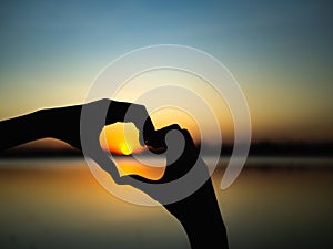 Silhouette hands to be heart shape on sunset background. Happy, Love, Valentine`s day idea, sign, symbol, concept