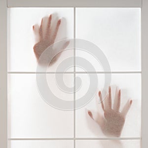 silhouette of hands trapped behind translucent screen