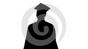 Silhouette Happy African American Male Student in graduation robe walking.