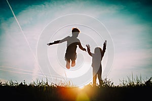 Silhouette of happy boy and girl enjoy sunset nature