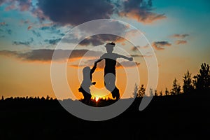 Silhouette of happy boy and girl enjoy sunset nature