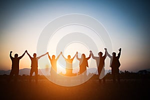 Silhouette of happy business human team making high hands over head in sunset sky evening time background for business teamwork