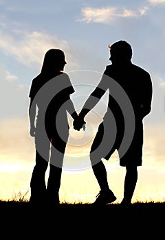 Silhouette of Happy Couple Holding Hands on Walk at Sunset