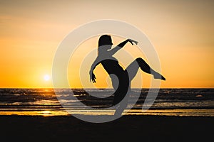 Silhouette of a happy dancer girl at sunset