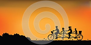 Silhouette of happy family cycling tandem bicycle with beautiful sky at sunset