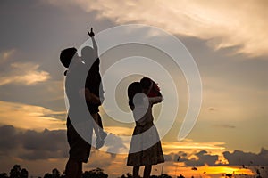 Silhouette of happy family father mother and son playing outdoors