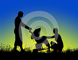 Silhouette of a happy family walking with stroller at sunset