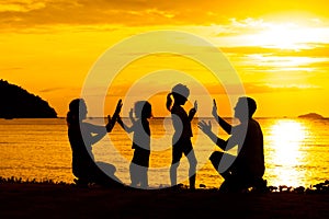 Silhouette of happy family who playing on the beach