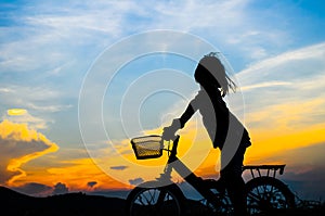 Silhouette of a happy girl outside riding bicycle