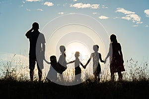 Silhouette of a happy large family at sunset.