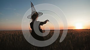 Silhouette of happy little girl dressed in a enchantress costume. The child presents himself as a sorceress, the concept