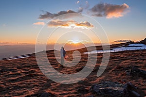 Silhouette of happy man enjoying a beautiful sunset on mountain peak Ladinger Spitz, Saualpe, Lavanttal Alps, Carinthia