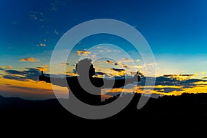 Silhouette Happy Man Standing on Hill at the Sunset on Mountain with Blue Sky. Enjoying Peaceful Moment Concept. Relaxing or