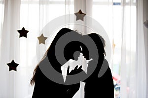 Silhouette of happy mother holding baby boy on hands, isolated
