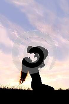 Silhouette of Happy Mother Playing Outside with Baby