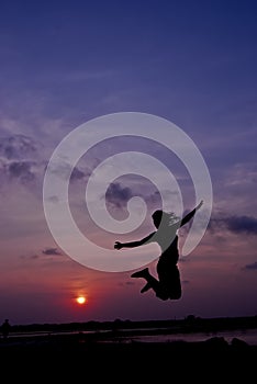 Silhouette happy woman jumping against beautiful in sunset. Free