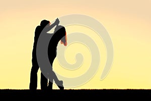 Silhouette of Happy Young Couple Dancing at Sunset