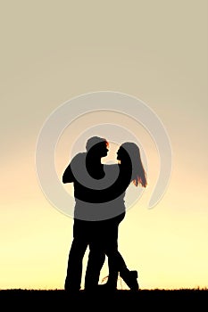 Silhouette of Happy Young Couple Dancing at Sunset