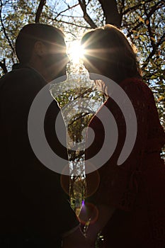 Silhouette of happy, young couple standing face to face in fall wooded area