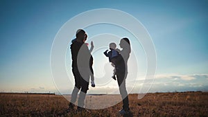 A silhouette happy young family. Happy family at sunset. Father, mother and two children having fun and playing in