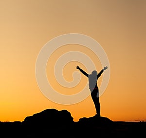 Silhouette of happy young woman against beautiful colorful sky.