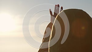 Silhouette of a happy young woman stretches out her hand to the sun. faith in god dream religious concept.